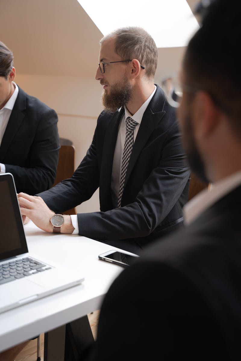 Group of businessmen in a modern office actively engaged in a meeting.